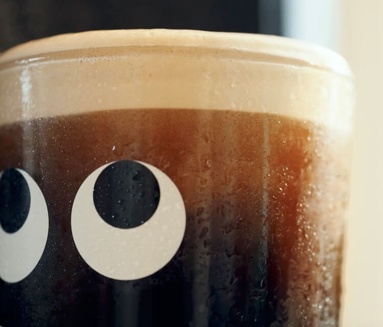 Close-up of Camden Stout with a creamy head in a branded glass